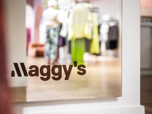 Subtiele logo-sticker onderaan een winkelspiegel in de winkel van Maggy’s
