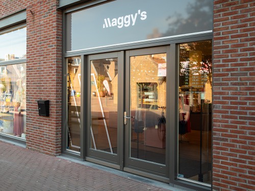 Gevel van Maggy’s met glanzende belettering van het logo in spiegelfolie