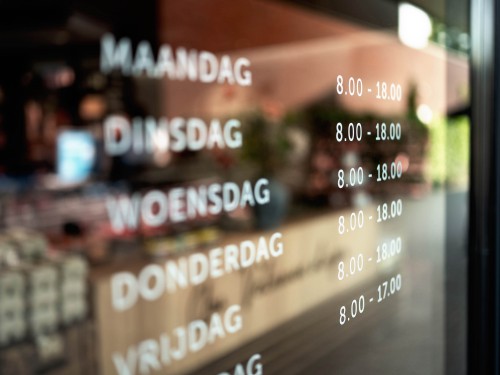 raamstyling met raamstickers van logo en openingstijden in witte glasfolie voor keurslager in voorthuizen