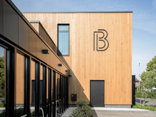 Ontwerp en productie gevellogo in zwart acrylox op houten gevel 
