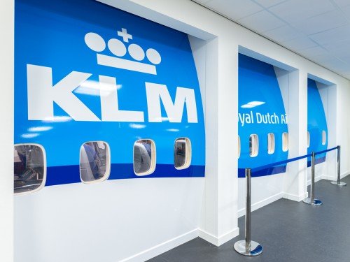 Fotowanden uitgevoerd in groot formaat print, xl printing op wand en belettering van vliegtuig in huisstijl KLM voor MBO Landstede Zwolle