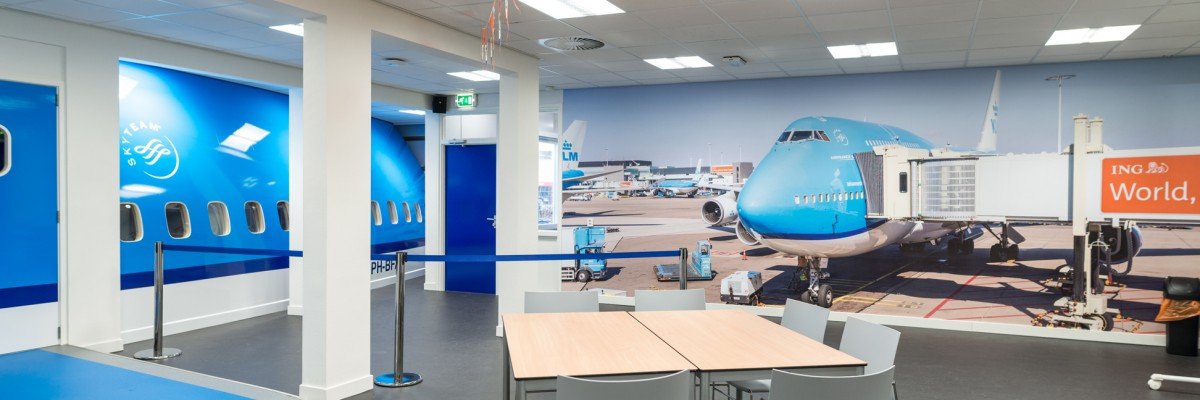 Fotowanden uitgevoerd in groot formaat print op wand en belettering van vliegtuig in huisstijl KLM voor MBO Landstede Zwolle