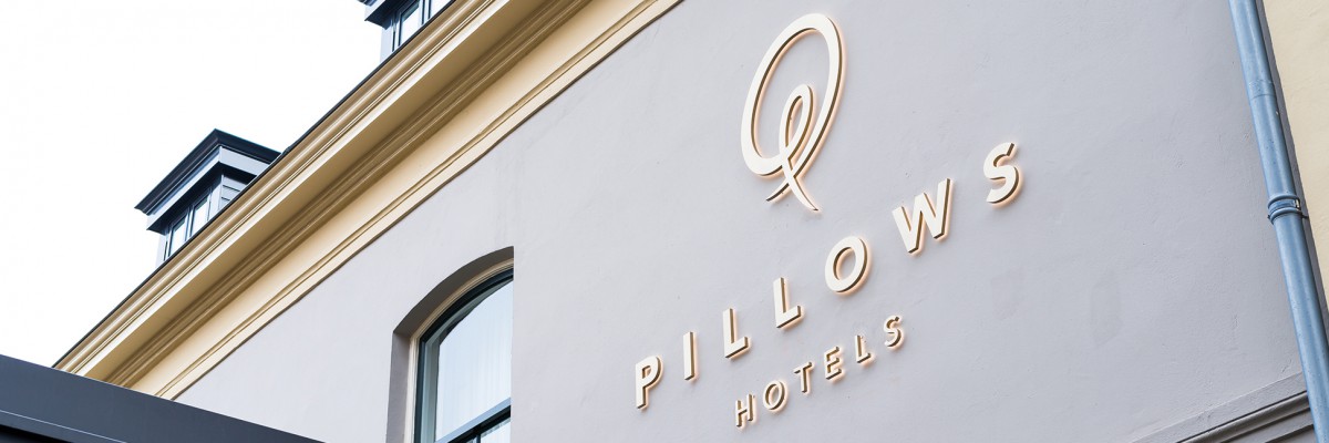 Signing – routing, facade styling in illuminated channel letters, advertising pillars in wood and brass Hotel Pillows Zwolle